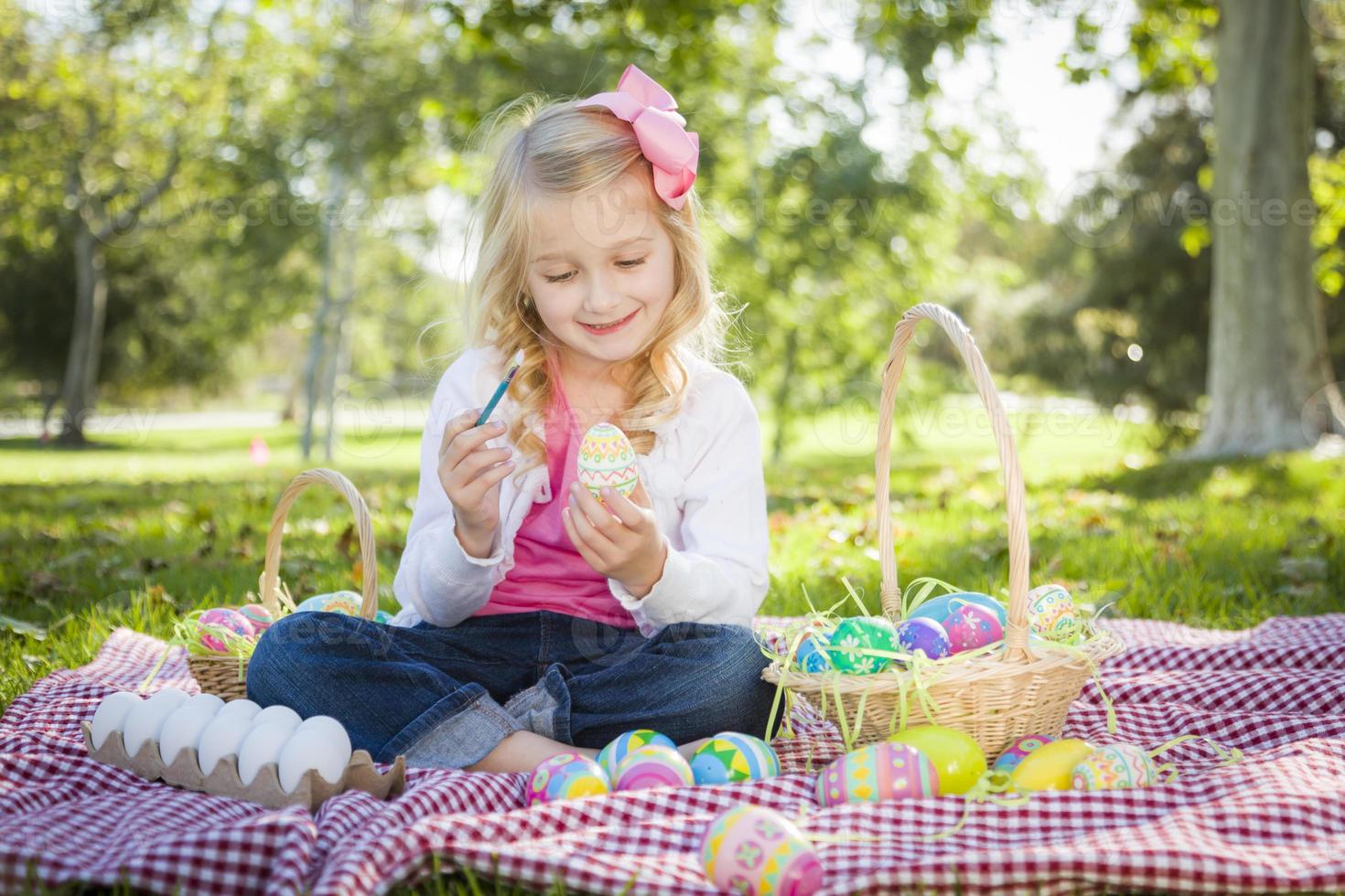 linda garota colorindo seus ovos de páscoa com pincel foto