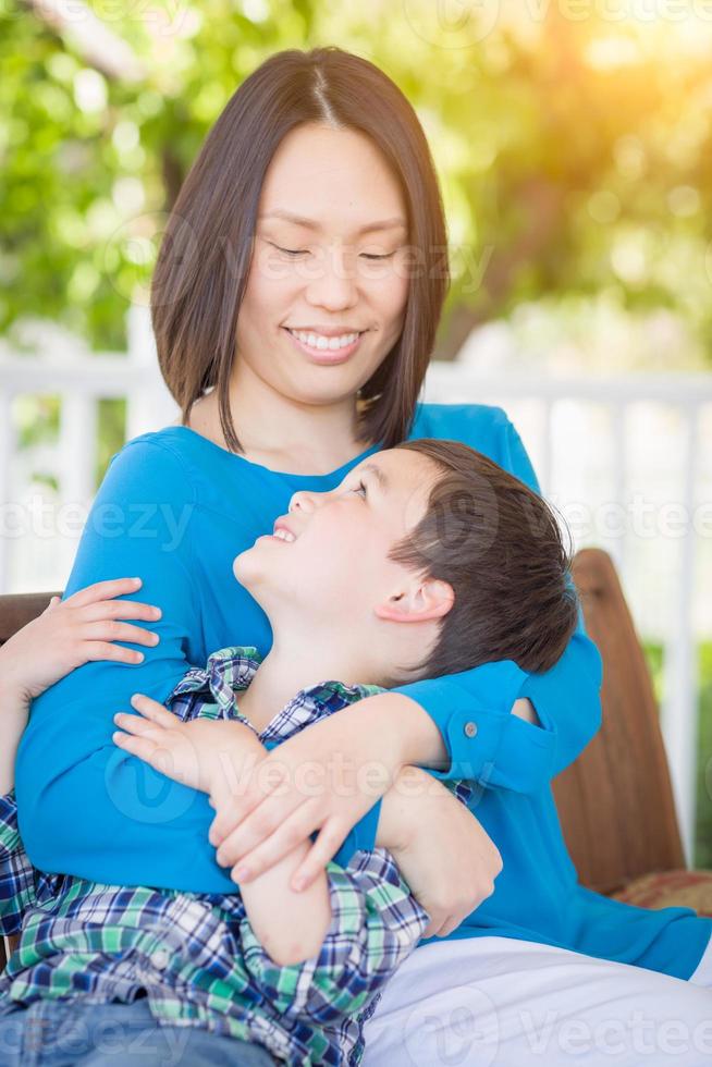 retrato ao ar livre da mãe chinesa com seu menino mestiço chinês e caucasiano foto