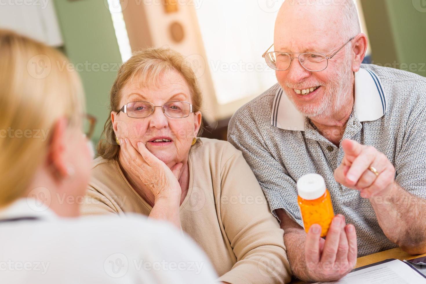 médico ou enfermeiro explicando medicamentos prescritos para casal adulto sênior foto