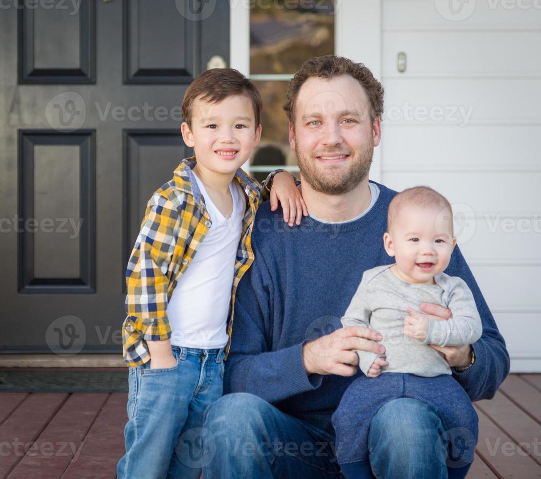 pai de raça mista e filhos na varanda da frente foto