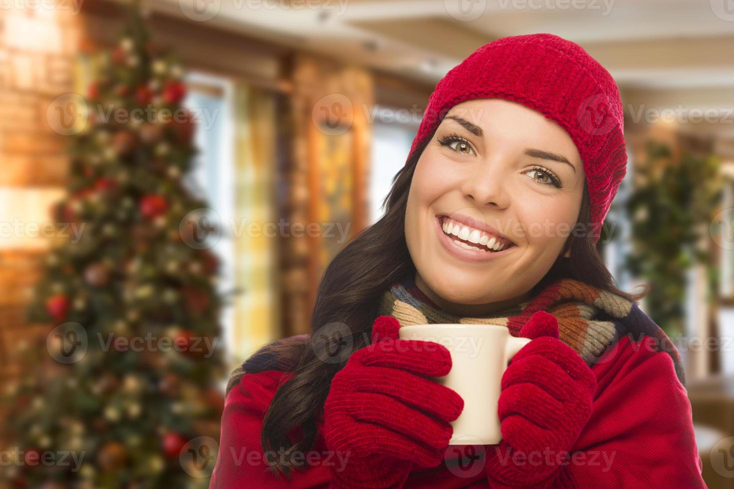 mulher de raça mista usando chapéu e luvas em cenário de natal foto