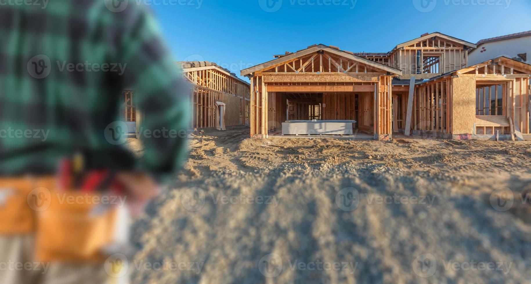 empreiteiro na frente da estrutura de madeira da casa nova no canteiro de obras foto