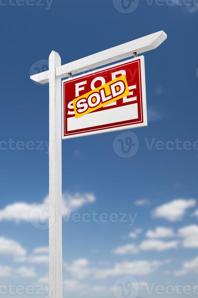 voltado para a direita vendido para venda sinal de imóveis em um céu azul com nuvens. foto