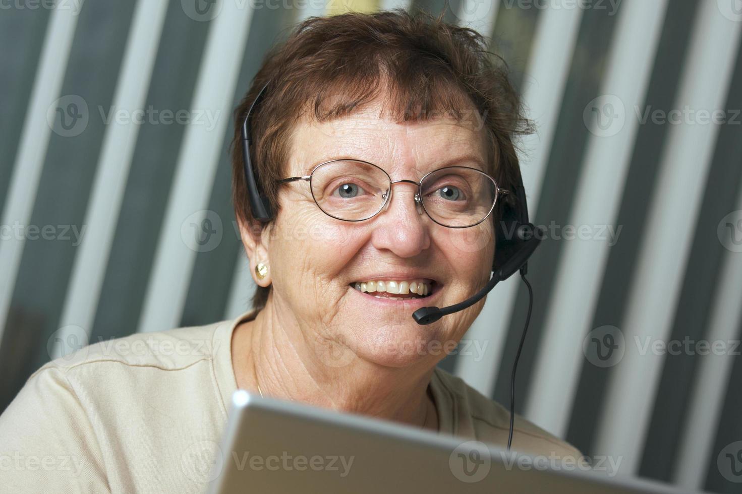 adulto sênior sorridente com fone de ouvido de telefone foto