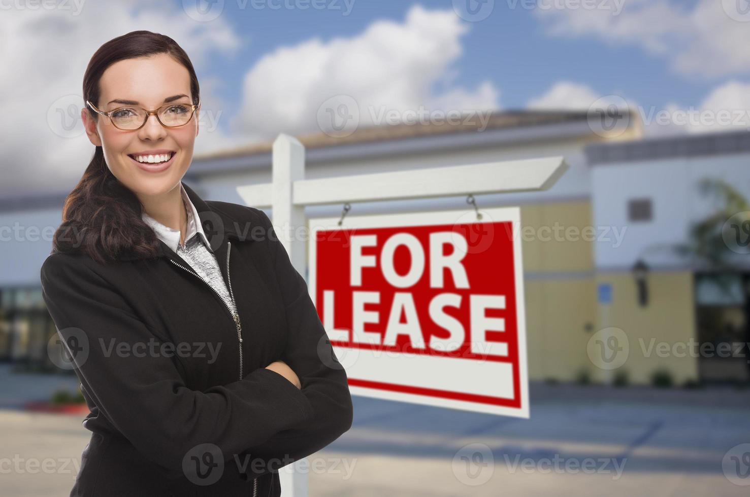 mulher em frente a prédio comercial e sinal de locação foto