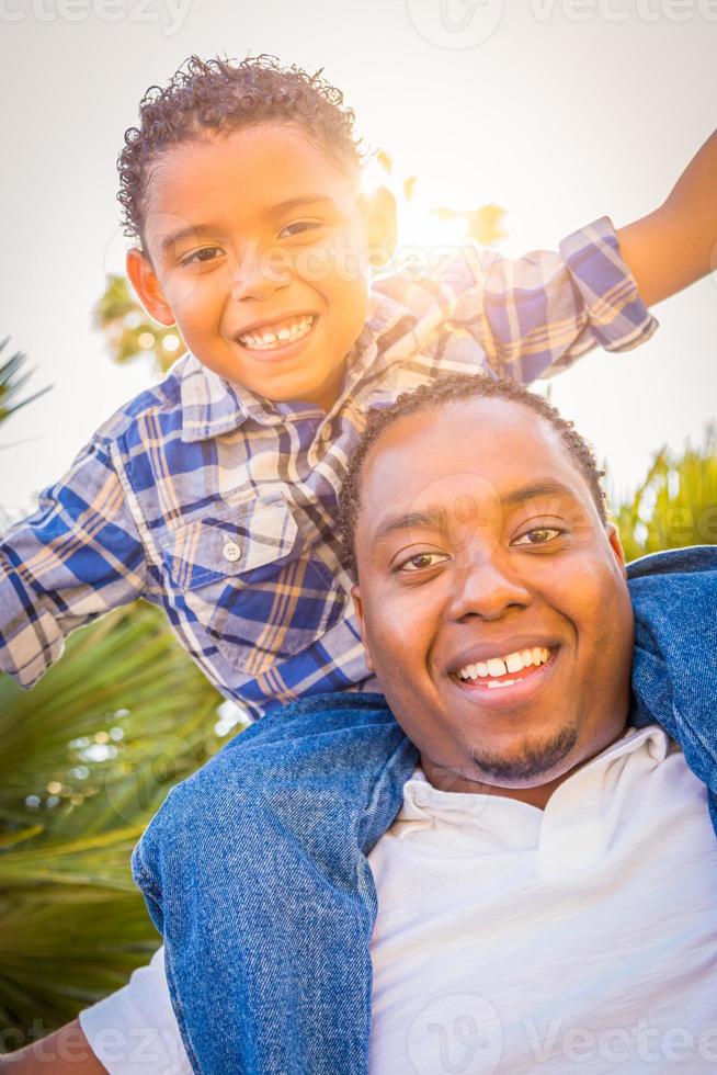 filho de raça mista e pai afro-americano brincando juntos ao ar livre. foto