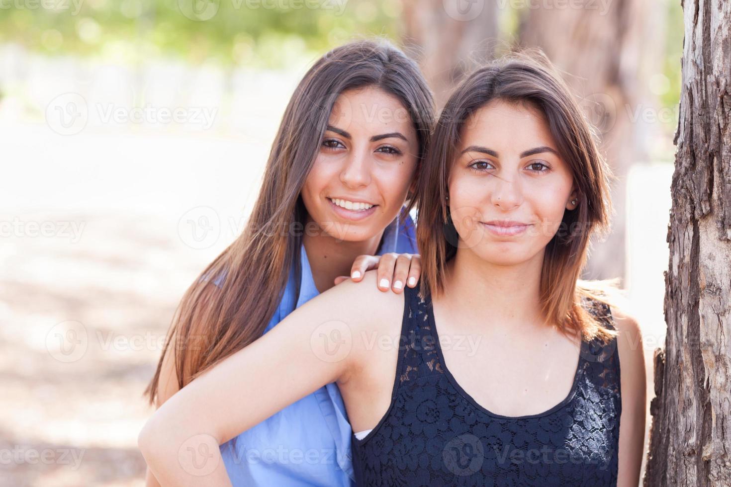 retrato de duas lindas irmãs gêmeas étnicas ao ar livre. foto