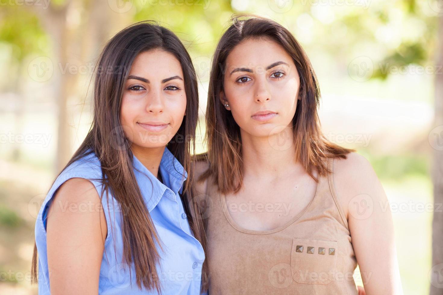 retrato de duas lindas irmãs gêmeas étnicas ao ar livre. foto