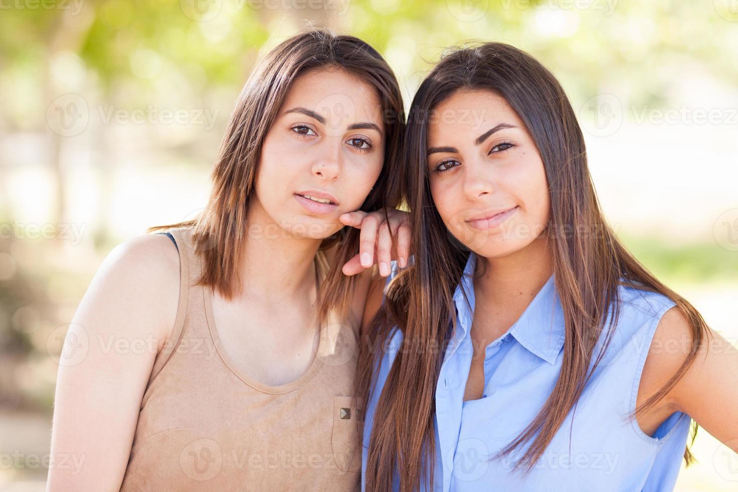 retrato de duas lindas irmãs gêmeas étnicas ao ar livre. foto