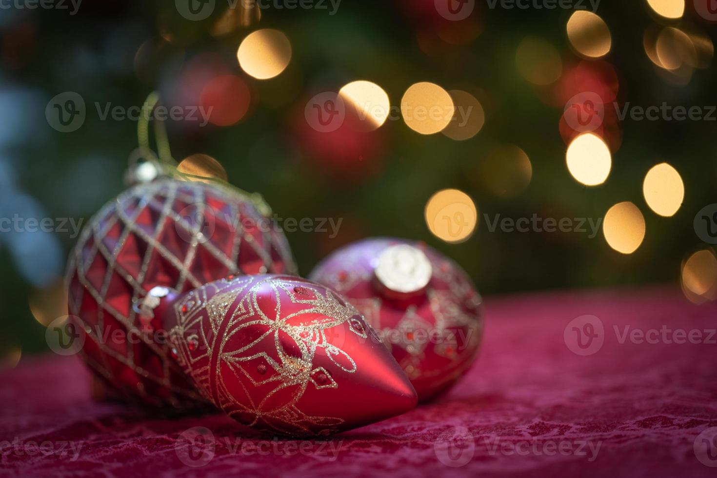 enfeites de natal elaborados sobre a mesa em frente à árvore iluminada foto