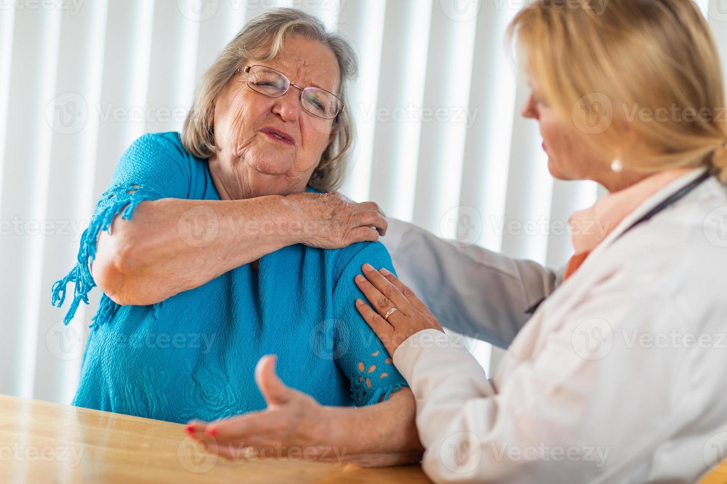 mulher adulta sênior conversando com médica sobre ombro dolorido foto