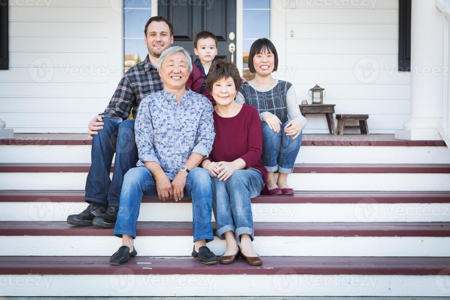 família chinesa e caucasiana sentada na varanda da frente foto