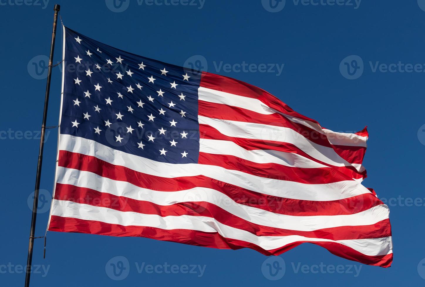 bandeira americana balançando ao vento contra um céu azul profundo foto