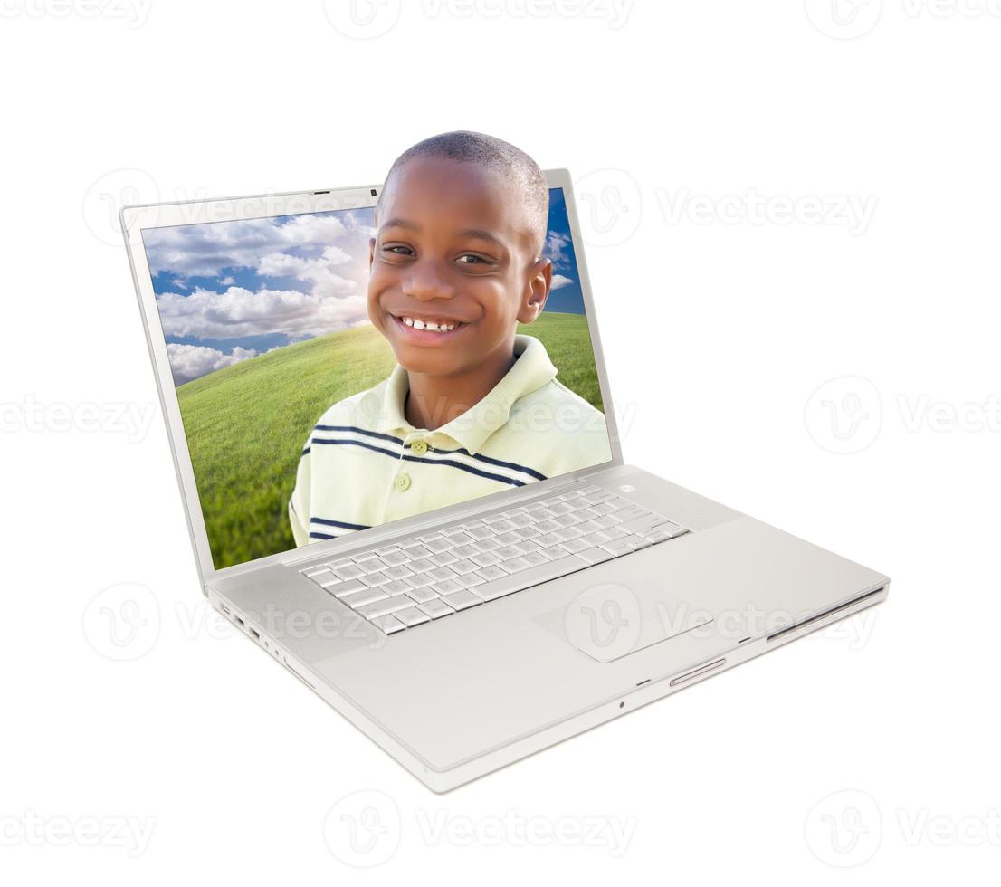 feliz menino afro-americano no laptop foto