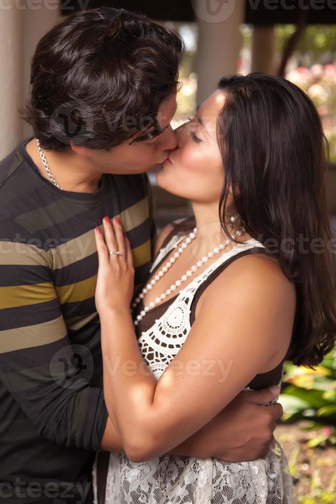 atraente casal hispânico beijando ao ar livre foto