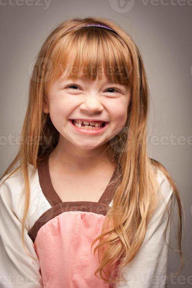 retrato divertido de uma adorável garota ruiva em cinza foto