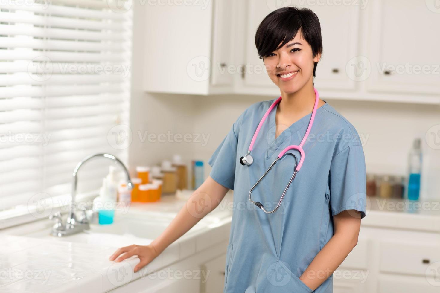 sorridente atraente médico ou enfermeira de raça mista em um escritório foto