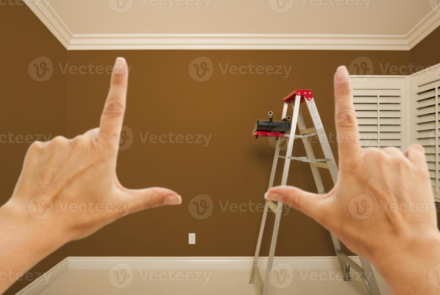 mãos emoldurando o interior da parede pintada de marrom foto