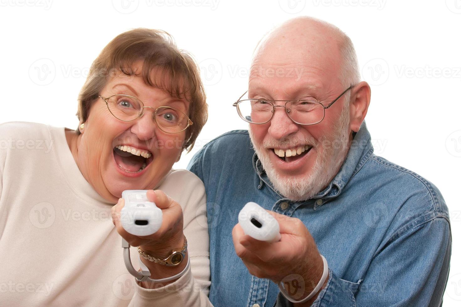 casal sênior feliz joga videogame com controles remotos foto