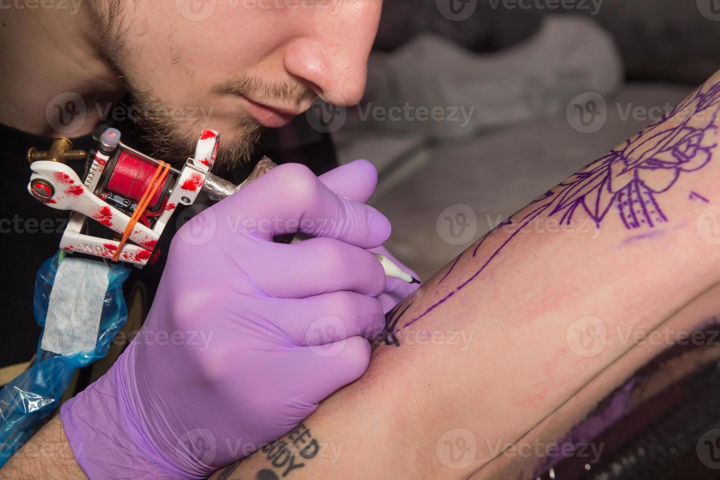 tatuador está fazendo tatuagem foto