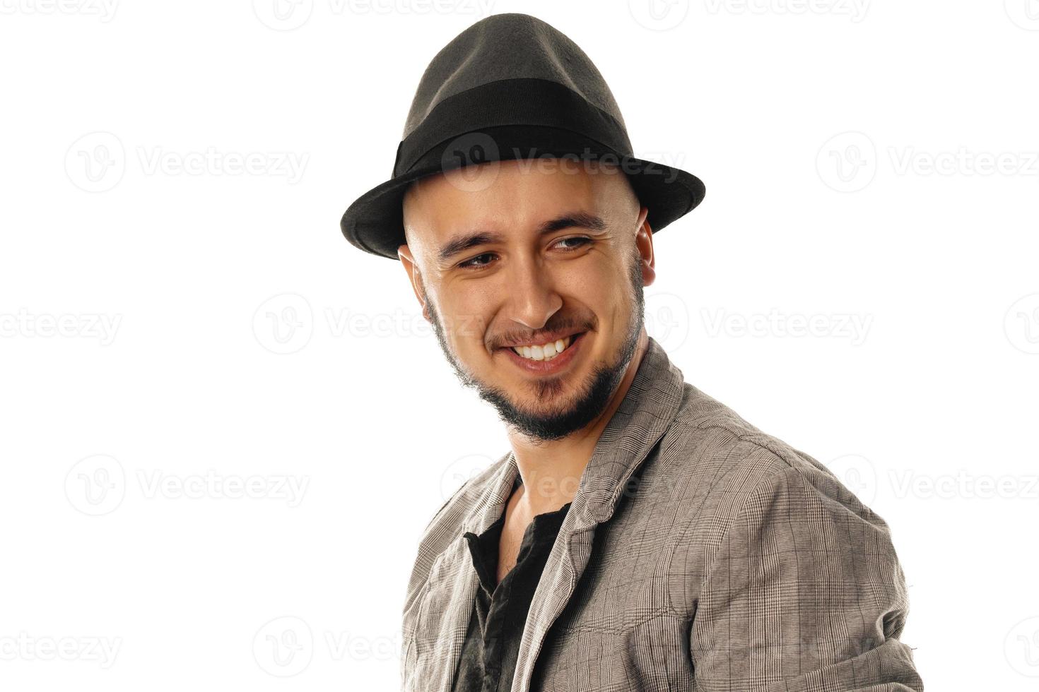 jovem bonito de chapéu e jaqueta olhando para longe e sorrindo foto