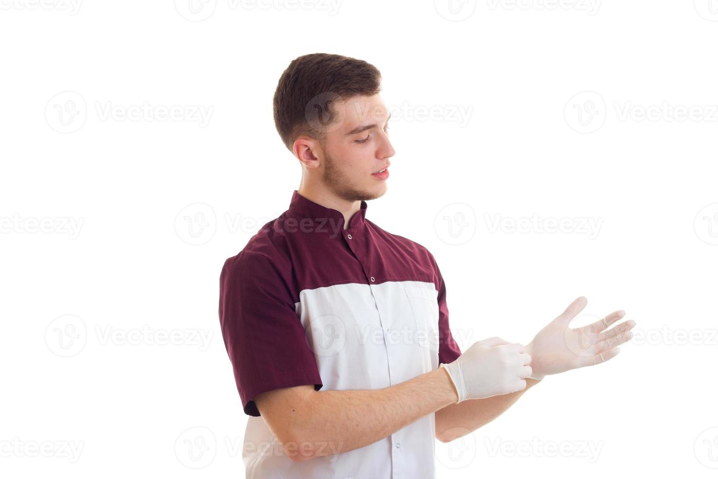 um jovem assistente de laboratório coloca as mãos em close-up de luvas brancas foto