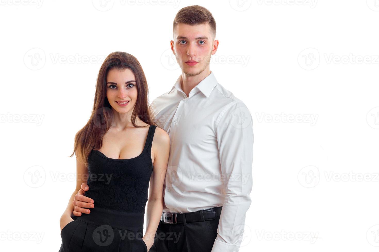 uma jovem encantadora em um vestido preto ao lado de um cara bonito em uma camisa branca foto