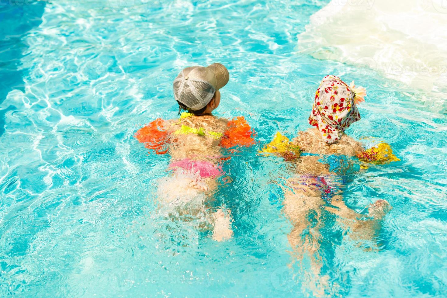 duas crianças brincando na piscina foto