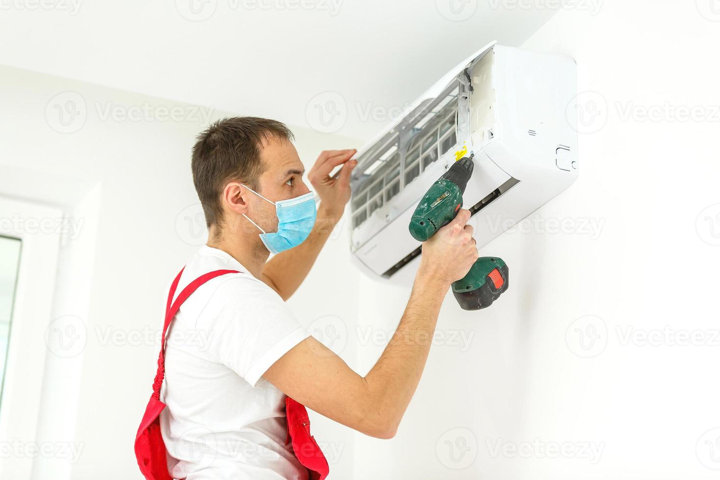 técnico masculino limpeza de ar condicionado dentro de casa foto