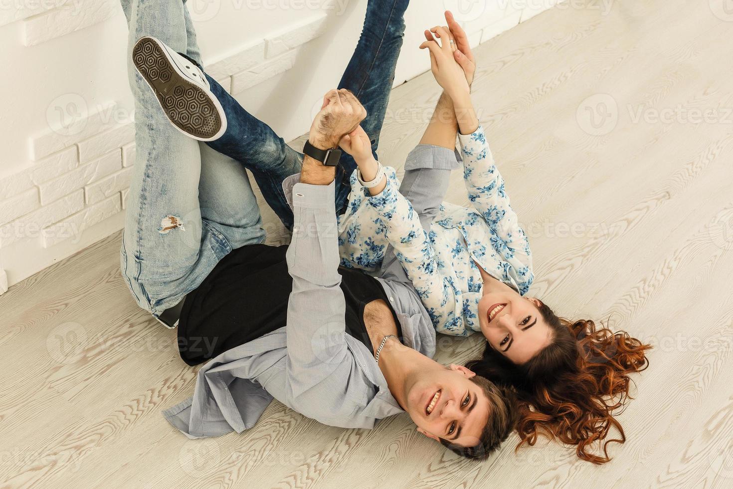 casal jovem feliz deitado no chão da casa nova e escolhendo a cor da paleta foto