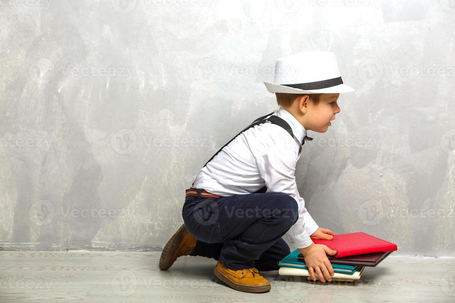 estudante do ensino fundamental carregando cadernos sobre um fundo cinza foto