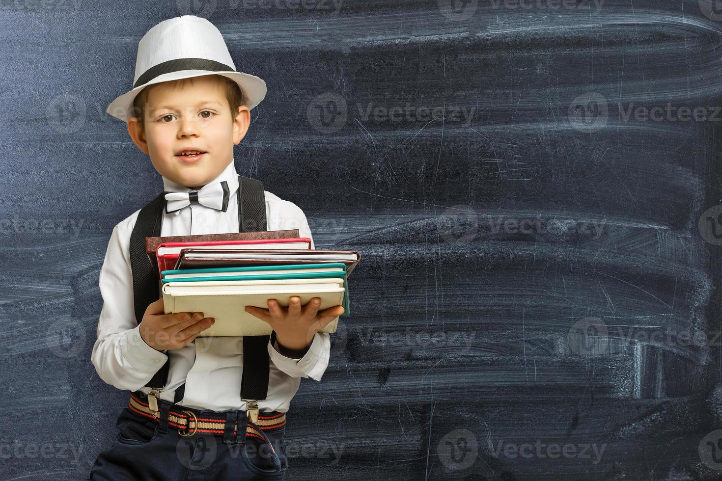 de volta à escola. menino engraçado em óculos apontando para cima no preto foto