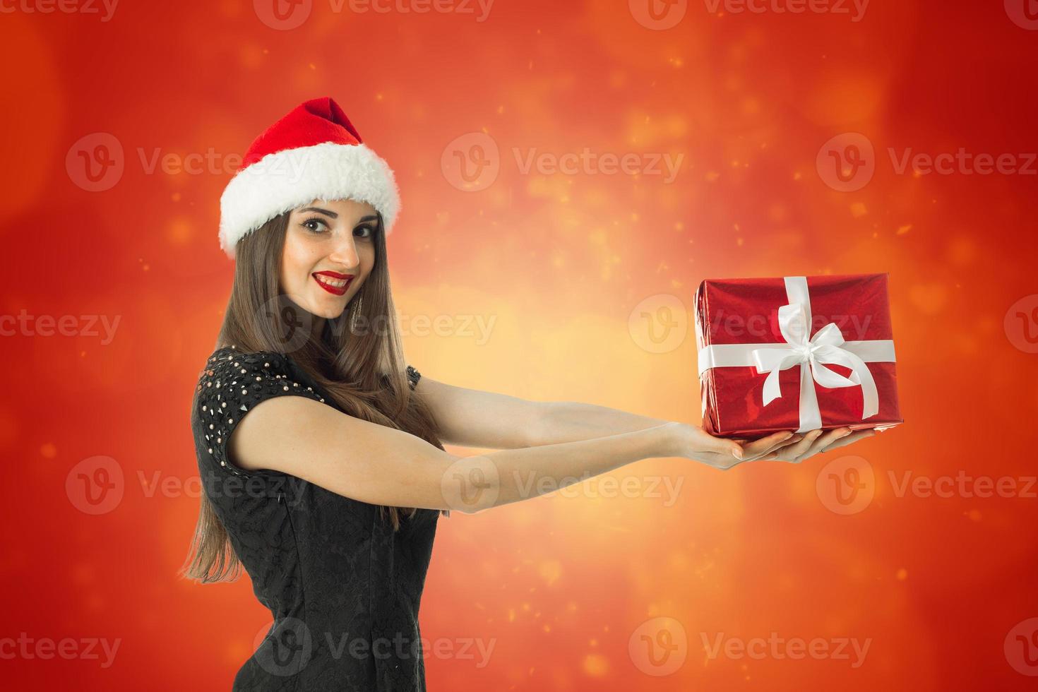 mulher encantadora com chapéu de Papai Noel sorrindo foto