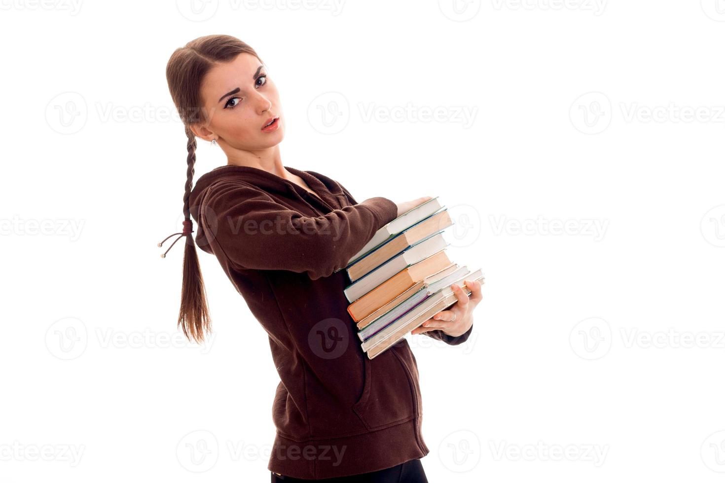 linda jovem estudante morena com um monte de livros nas mãos, isolado no fundo branco foto