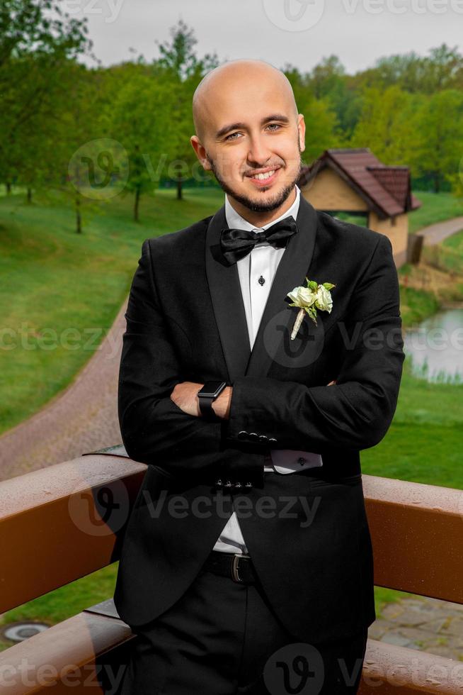 alegre homem elegante de terno sorrindo na câmera ao ar livre foto