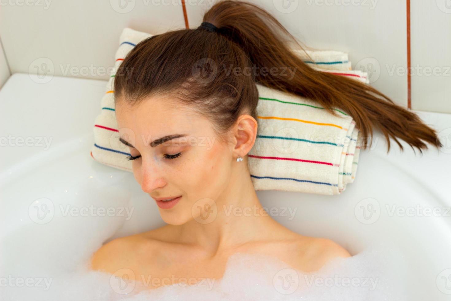 menina toma uma espuma de banho com os olhos fechados foto