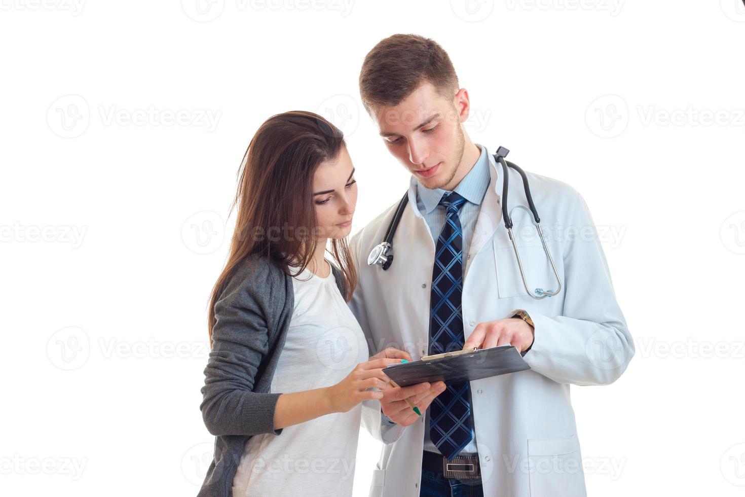 uma jovem está ao lado de um médico e olhando para o close-up do tablet foto