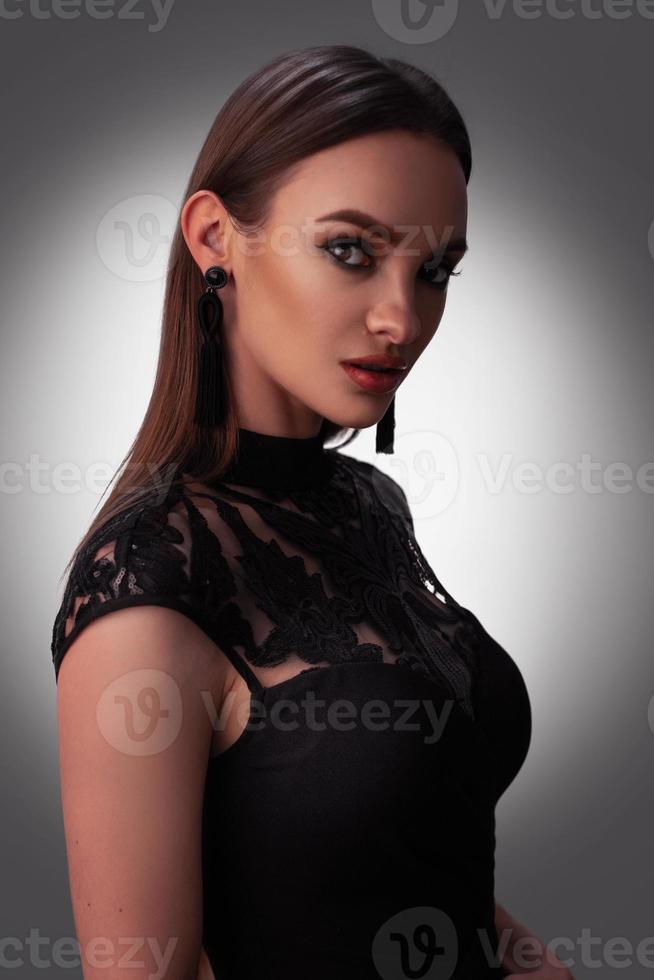 jovem sexy vestido preto no estúdio foto