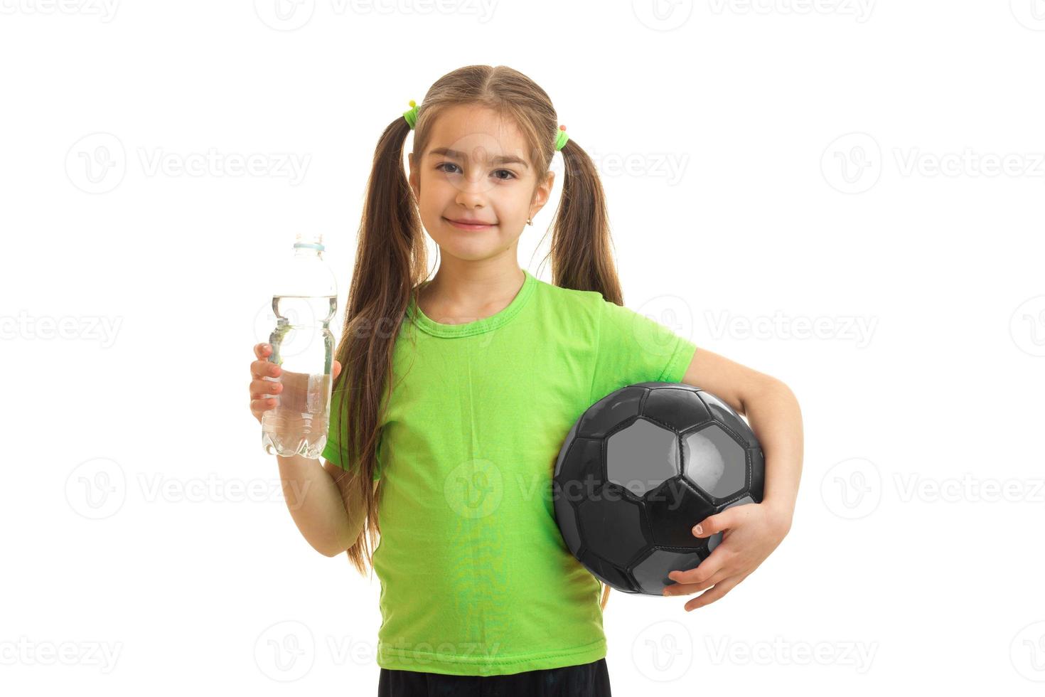 menina encantadora de uniforme verde com bola de futebol foto