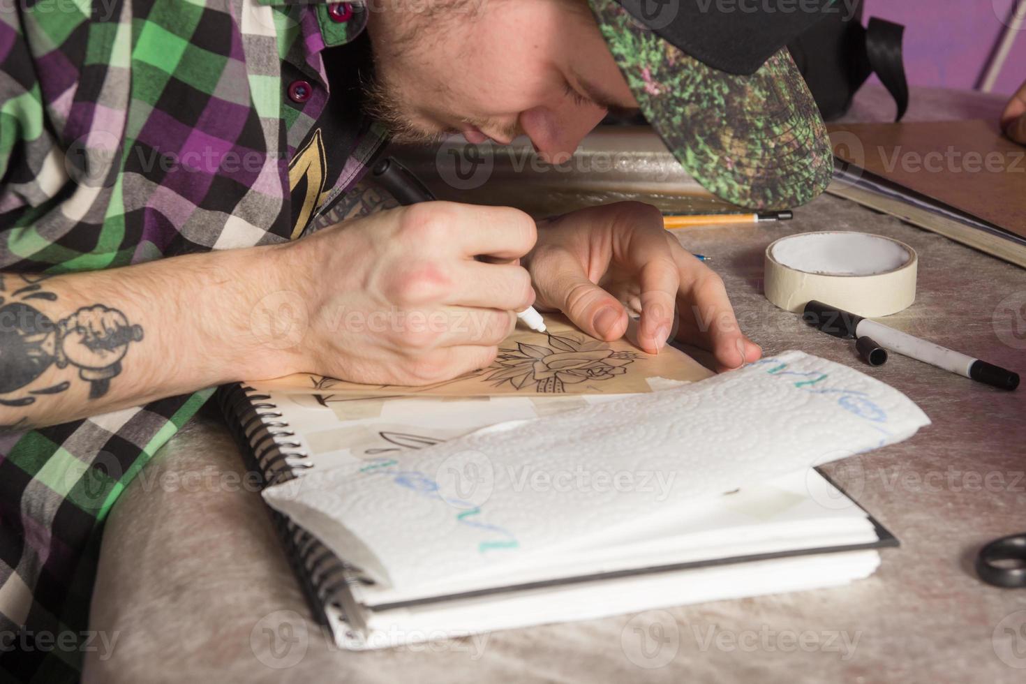 tatuador está fazendo tatuagem foto