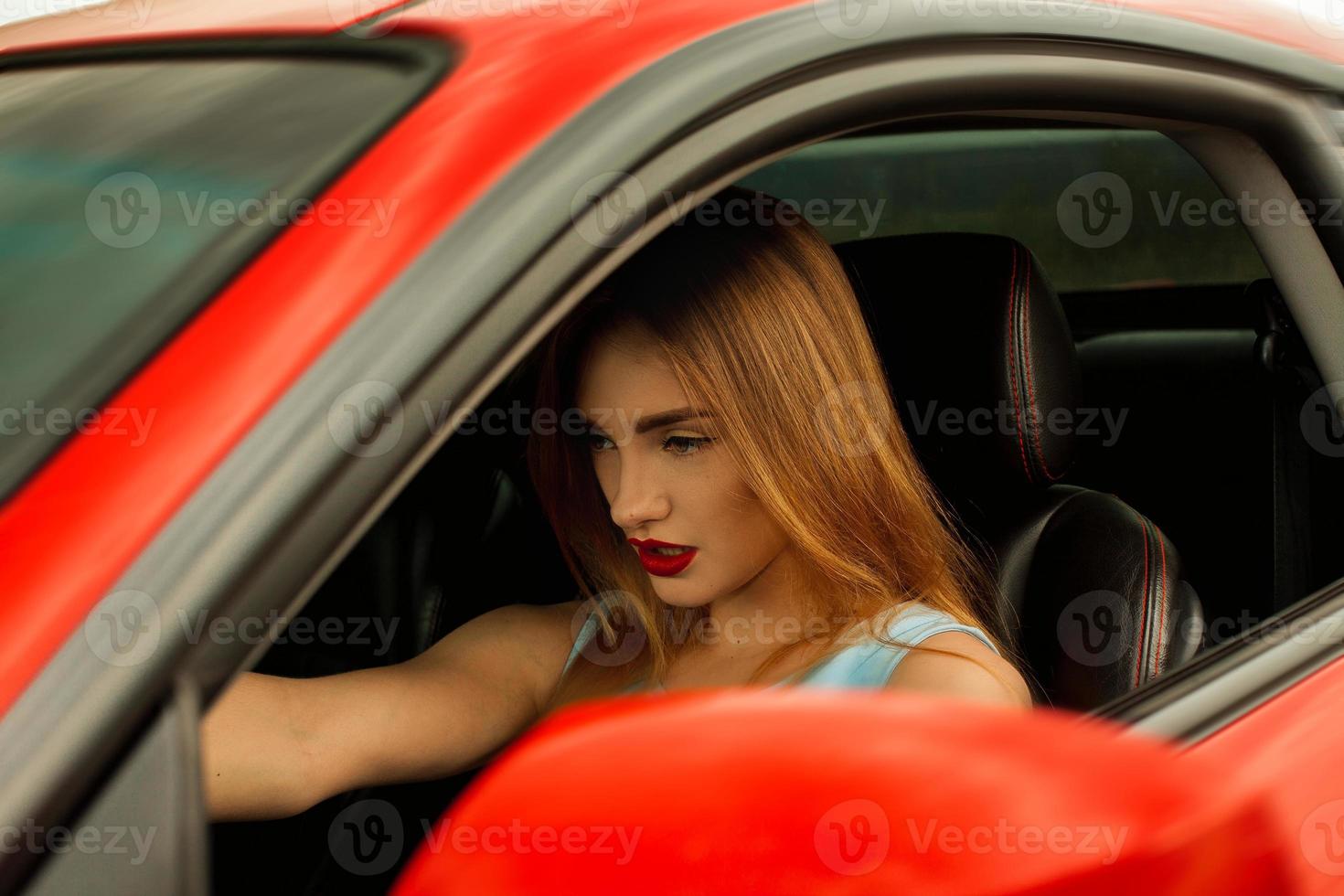 mulher com lábios vermelhos dirigindo um carro foto