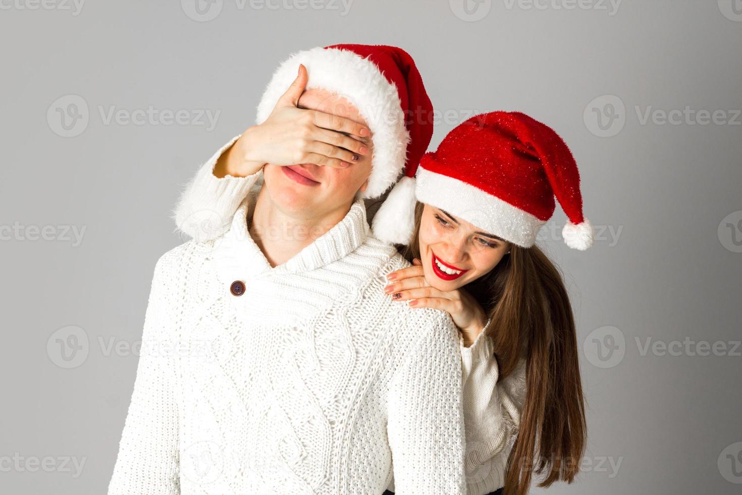 casal apaixonado comemora o natal com chapéu de papai noel foto