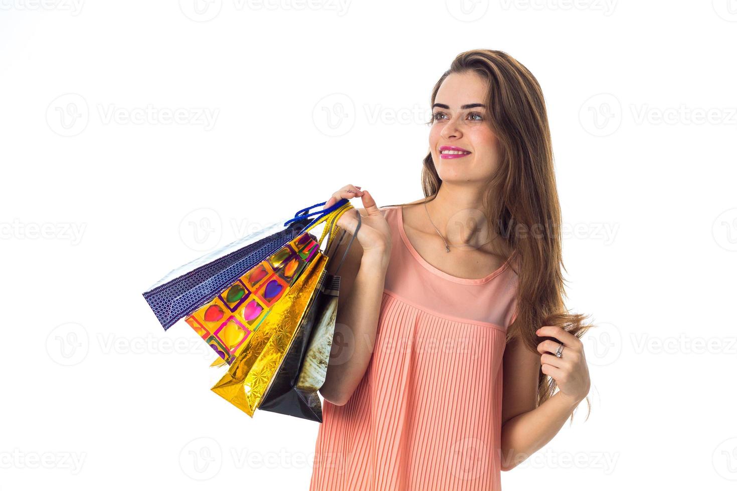 linda garota tem na mão um monte de pacotes diferentes e sorrindo isolado no fundo branco foto