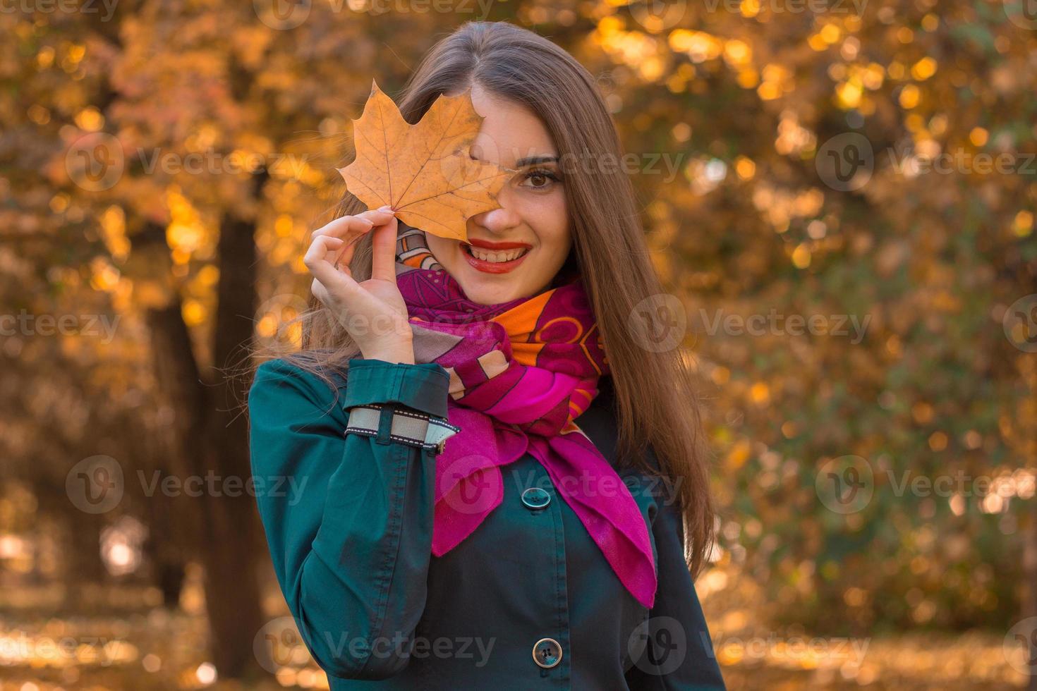 linda garota atraente no lenço rosa mantém o lençol perto dos olhos e sorri foto