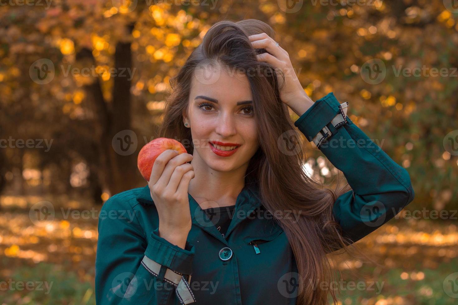 garota pin-up segura uma maçã na mão e melhora o cabelo closeup foto