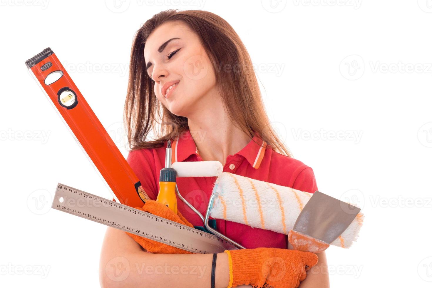 retrato de uma jovem e bonita morena construtora faz renovação com ferramentas nas mãos, isoladas no fundo branco foto