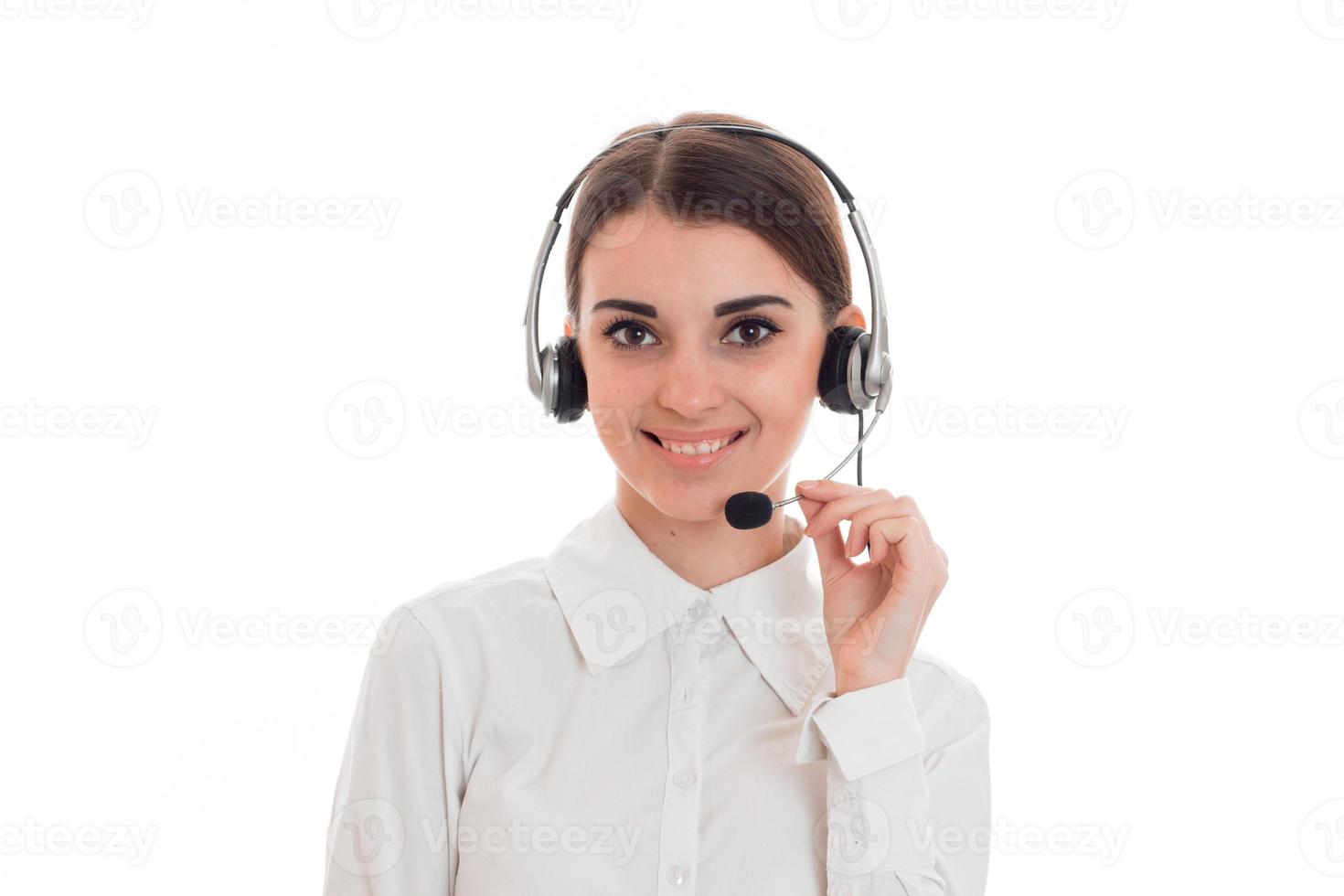 jovem senhora de negócios feliz com fone de ouvido e microfone olhando para a câmera e sorrindo isolado no fundo branco foto