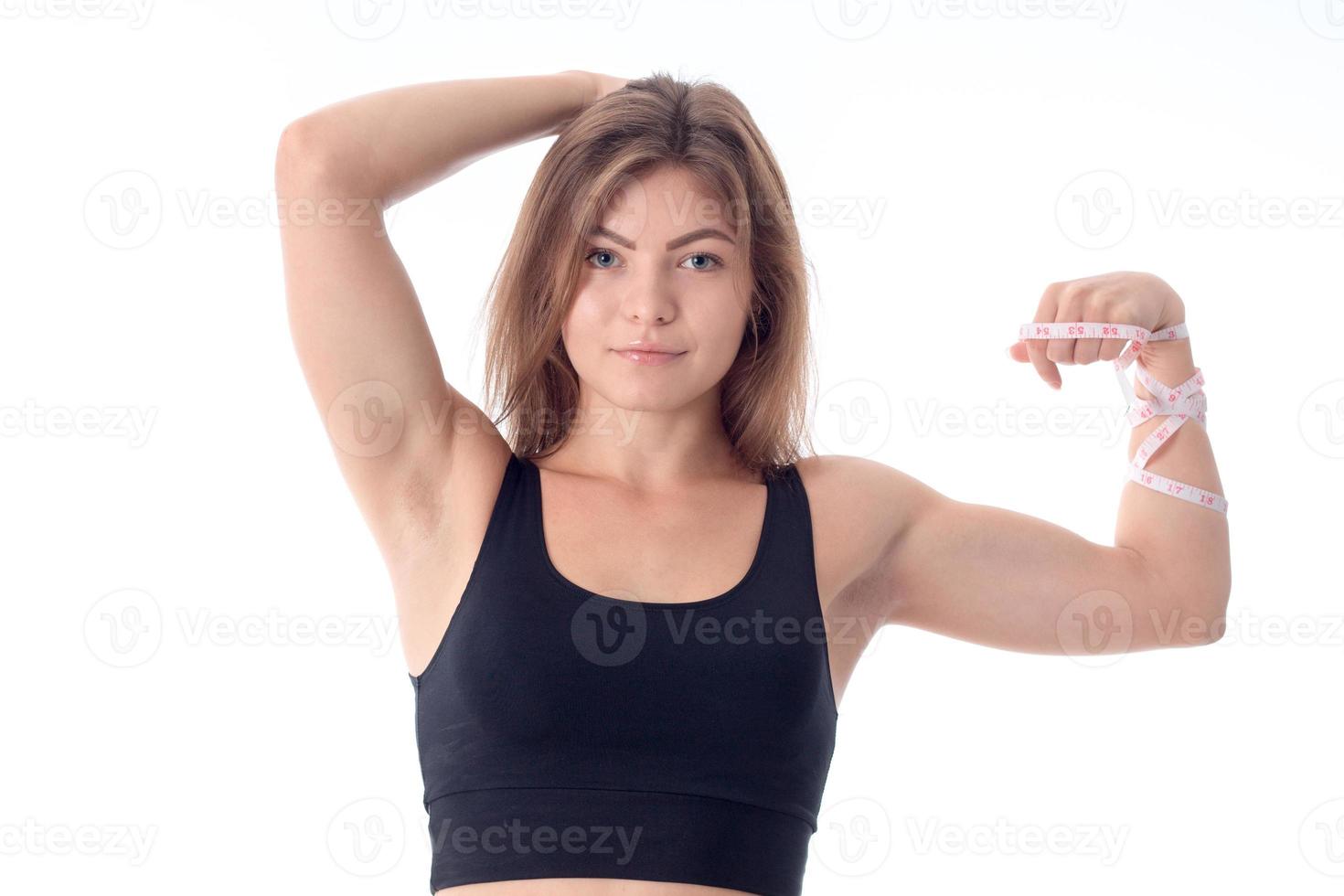 close-up de uma linda garota atlética esbelta que está sorrindo e mostrando seu bíceps foto