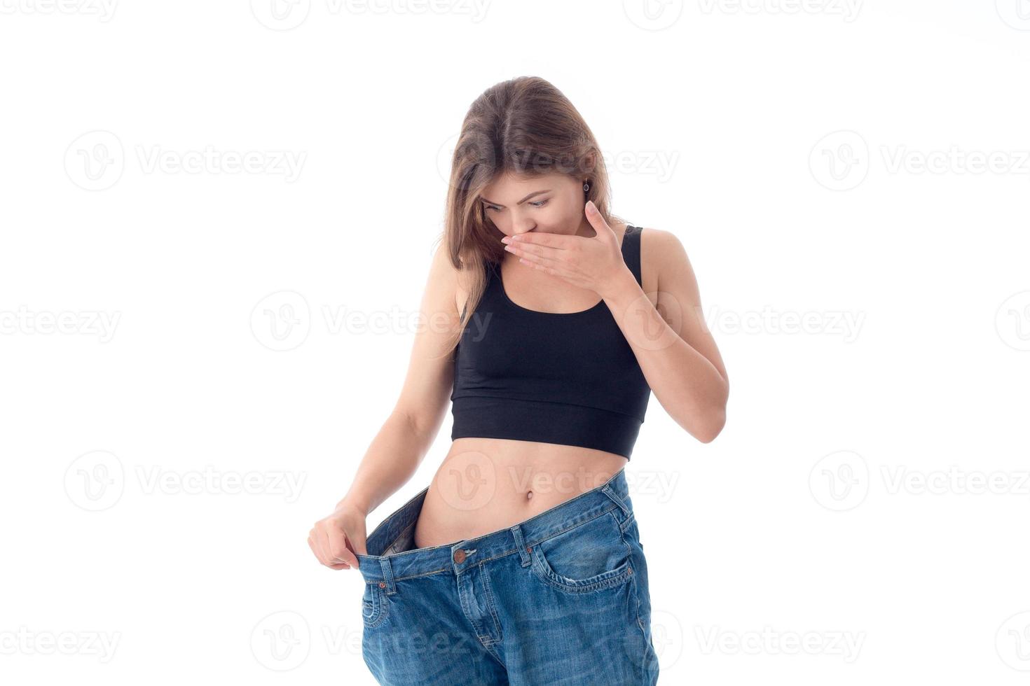 menina magro vestindo uma calça larga isolada no fundo branco foto