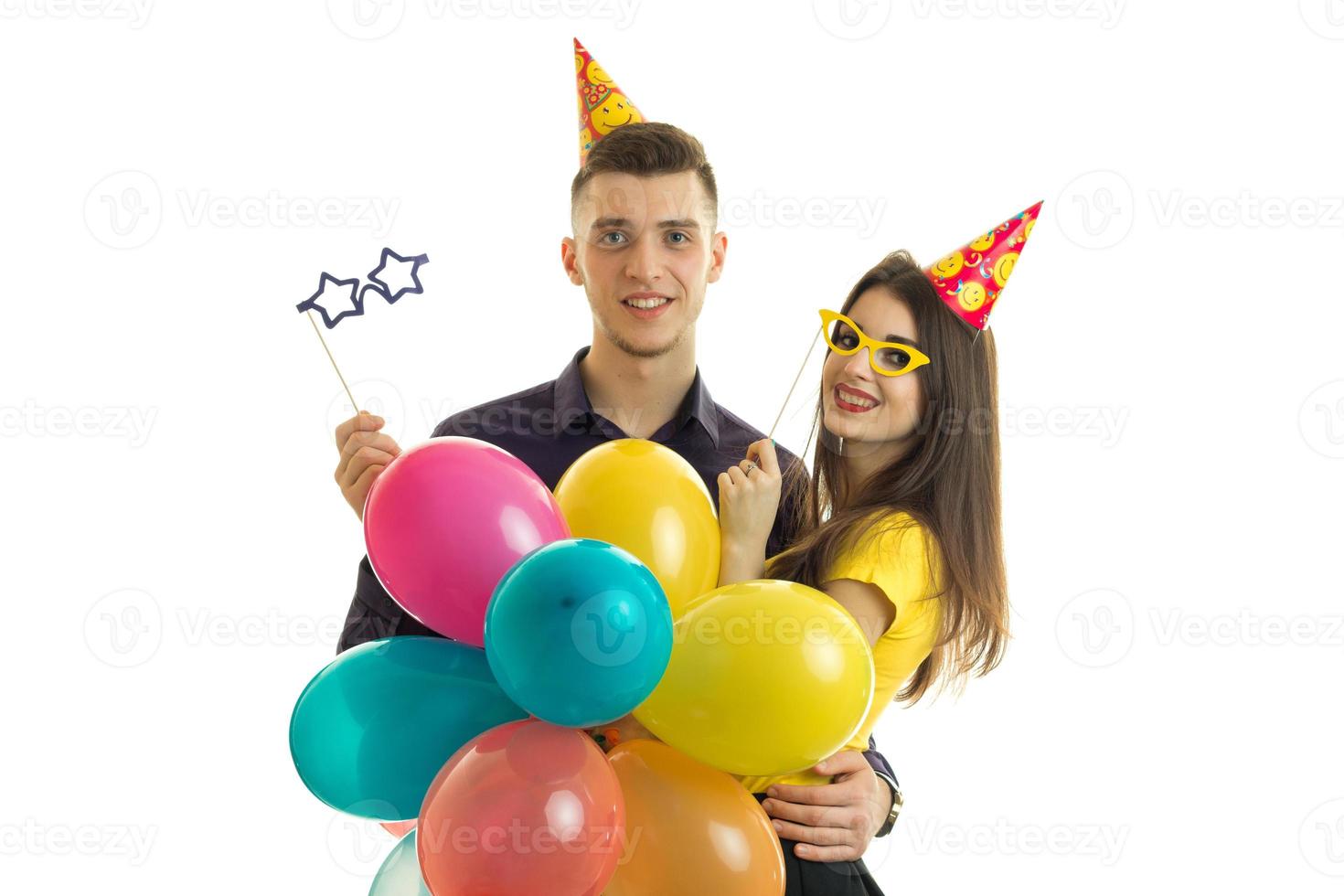 cara bonito e linda garota em roupas elegantes carregando um monte de balões e bonecos de papel para cada aniversário foto